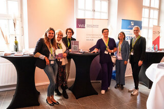 Das Bild zeigt eine Gruppe von sechs Frauen an einem Stehtisch. Sie stehen vor einem Banner des Verbands deutscher Unternehmerinnen und lächeln.