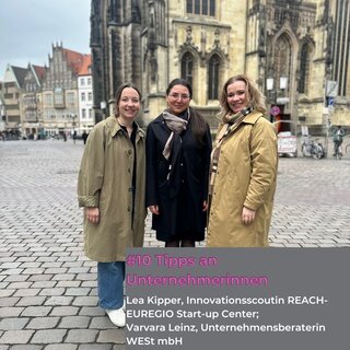 Auf dem Bild stehen drei Frauen vor einer historischen Kulisse. Sie lächeln freundlich und tragen bequeme Kleidung.